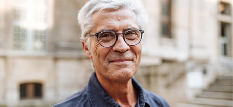 A senior man with glasses smiling